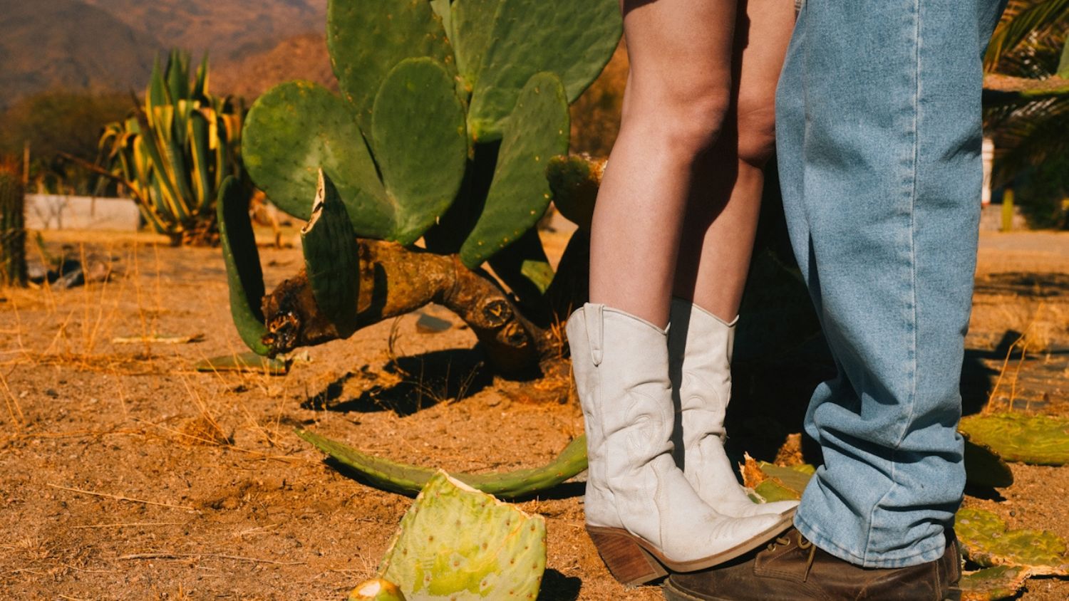 A couple and their feet standing together in the desert