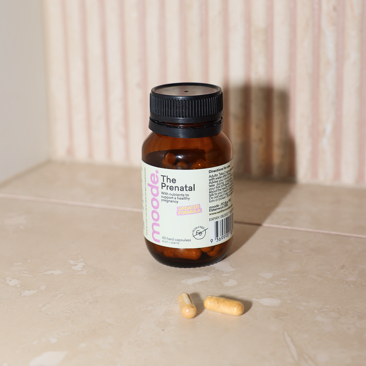 The Prenatal by moode bottle standing upright with the label facing forward, showing 60 hard capsules and AUST L 504773, beside two capsules.