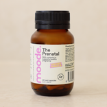 The Prenatal by moode, a 60 capsule amber glass bottle, lying beside two capsules on a cream stone surface.